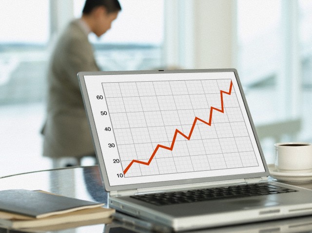 Graph showing profit on laptop with businessman working in the office